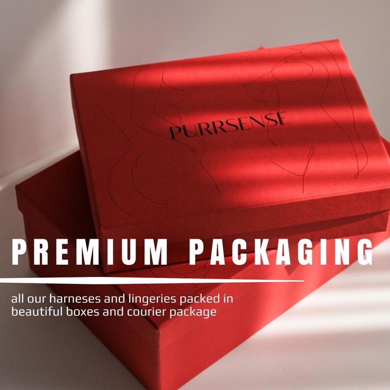 May include: Two stacked red boxes with the word "PURRSENSE" printed on the top box. The words "PREMIUM PACKAGING" are displayed in large white letters. The text "all our harnesses and lingeries packed in beautiful boxes and courier package" is also visible.