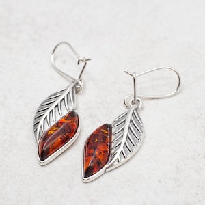 Introducing our stunning Baltic Amber Earrings, crafted with genuine Baltic amber in a beautiful marquise leaf design. These gorgeous dangle earrings are made with high quality sterling silver, adding the perfect touch of elegance to any outfit.