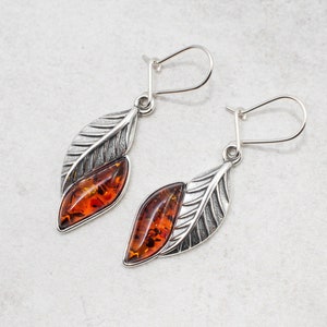 The marquise amber cabochon is not only a beautiful feature, but also boasts natural healing properties making these earrings not only a stunning accessory, but also a potential source of comfort and relief.
