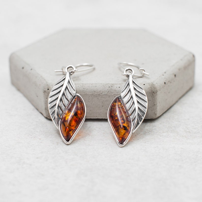 Experience the beauty of Baltic amber with our Amber Earrings. The stunning leaf design, solid sterling silver frame, and marquise amber cabochon create a one of a kind accessory that is sure to become a treasured part of your jewelry collection.