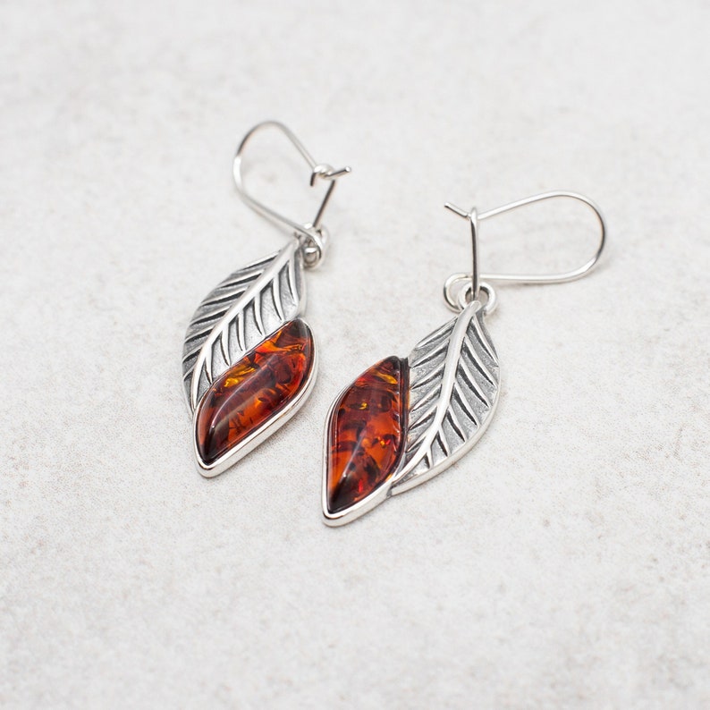 Introducing our stunning Baltic Amber Earrings, crafted with genuine Baltic amber in a beautiful marquise leaf design. These gorgeous dangle earrings are made with high quality sterling silver, adding the perfect touch of elegance to any outfit.