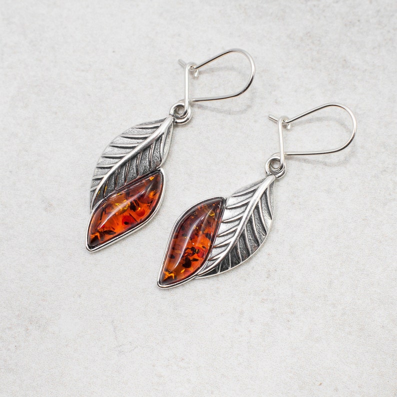 The marquise amber cabochon is not only a beautiful feature, but also boasts natural healing properties making these earrings not only a stunning accessory, but also a potential source of comfort and relief.