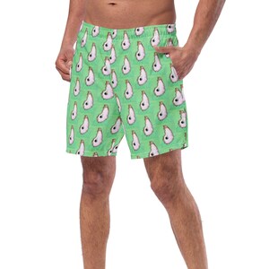 May include: Green swim trunks with a white and brown pattern of repeated images of a dog's head.