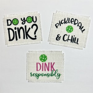May include: Three white fabric patches with pickleball-themed text. One says "Do you Dink?" with a green pickleball. Another says "Pickleball & Chill." The third says "Dink responsibly" with a pink and green design.