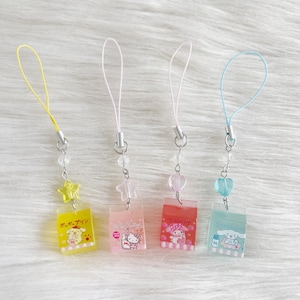 Può includere: Quattro ciondoli colorati per telefono con ciondoli in plastica trasparente con personaggi dei cartoni animati e testo giapponese. Ogni ciondolo ha un cinturino di colore diverso: giallo, rosa, rosa e blu. Ogni ciondolo ha una forma diversa: stella, stella, cuore e cuore.
