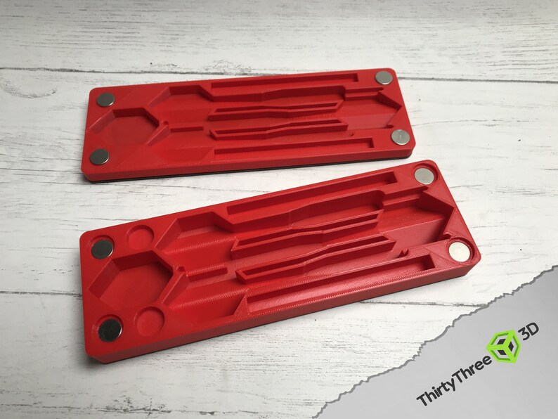 May include: Two red plastic trays with magnets on the sides. Each tray has multiple compartments of different sizes and shapes.