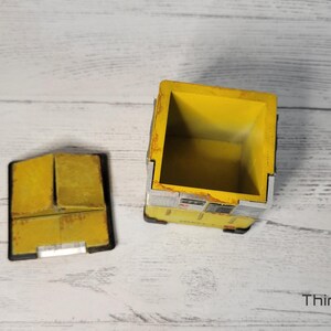 May include: A yellow and gray box with a lid. The box is open and the inside is empty. The box is made of wood and has a distressed look.