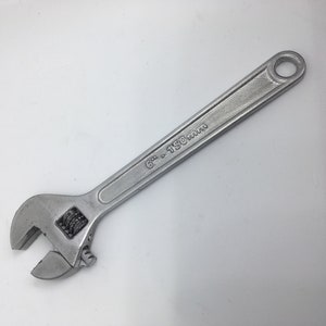 Puede incluir: Una llave inglesa de plata con una marca de 6" - 150 mm en el mango.