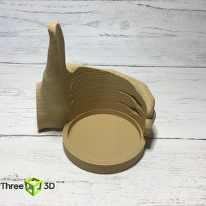 May include: A 3D printed beige thumbs up hand with a round, hollowed out center. The hand is giving a thumbs up gesture.