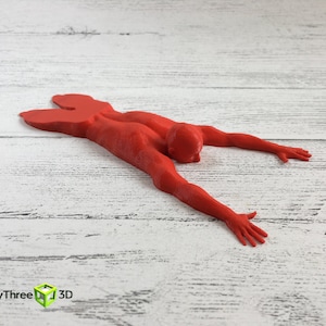 May include: A red 3D printed figurine of a person lying face down with arms outstretched.