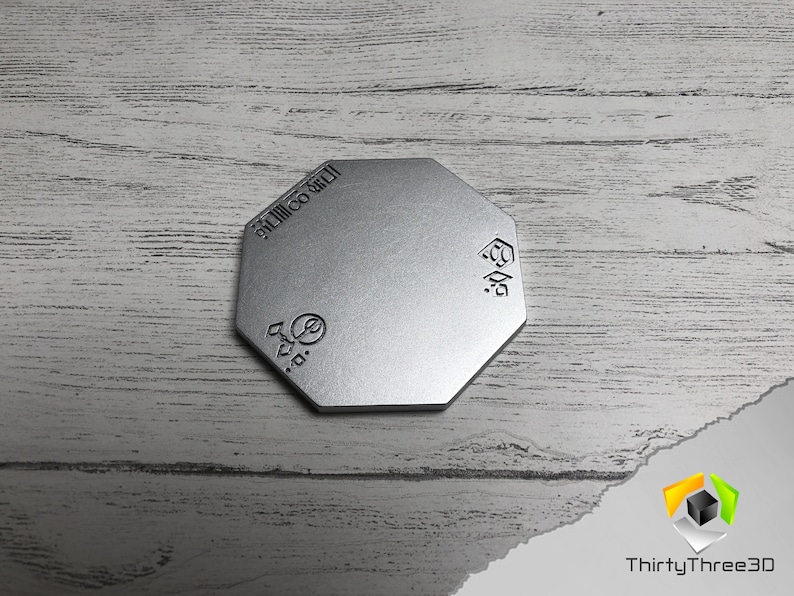 May include: A silver octagonal metal coaster with the text "3D Printed" and a logo on the top.