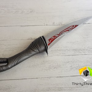 May include: A silver and red dagger with a hand-shaped handle. The blade has a red design on it.