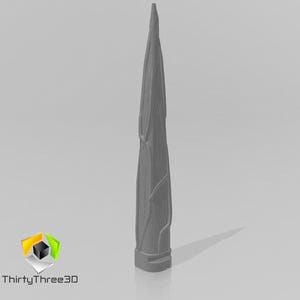 May include: A gray, 3D-printed object with a textured, elongated design, resembling a stylized tree trunk or spire. The object has a pointed top and a rectangular base. The logo "ThirtyThree3D" is in the lower left corner.
