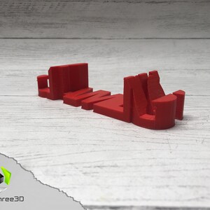 May include: A red 3D printed word "GAME" with each letter standing on its own. The letters are printed in a bold, blocky style.