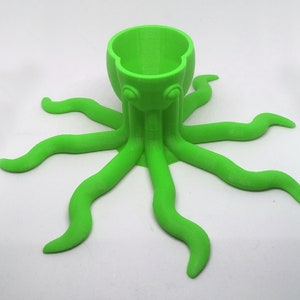 May include: A bright green 3D printed octopus with eight tentacles, designed to hold a single egg or small object.