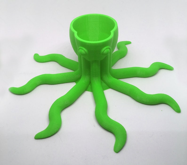 May include: A bright green 3D printed octopus with eight tentacles, designed to hold a single egg or small object.