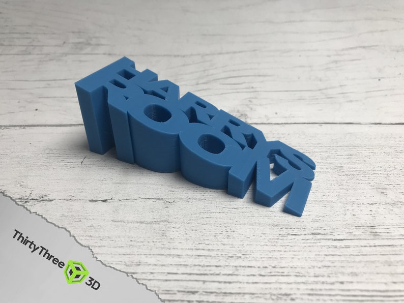 May include: A blue plastic doorstop shaped like the word "ROOM".