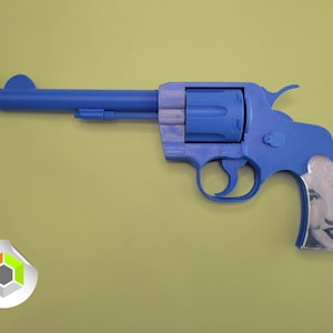 Op de afbeelding: Een blauw speelgoedrevolver met een oranje punt en een lachend gezicht op het handvat. Het speelgoedpistool staat tegen een geelgroene achtergrond. De revolver is een novelty-artikel.