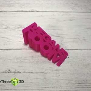 May include: A pink 3D printed word block that reads "MEGAN ROOM".