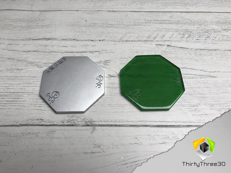 May include: Two octagonal shaped bases, one silver and one green. The bases are made of a smooth, hard material. The silver base has the text "SILICONE GEL" printed on it.