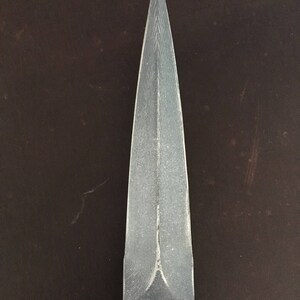 May include: A silver dagger with a sharp point and a textured blade.