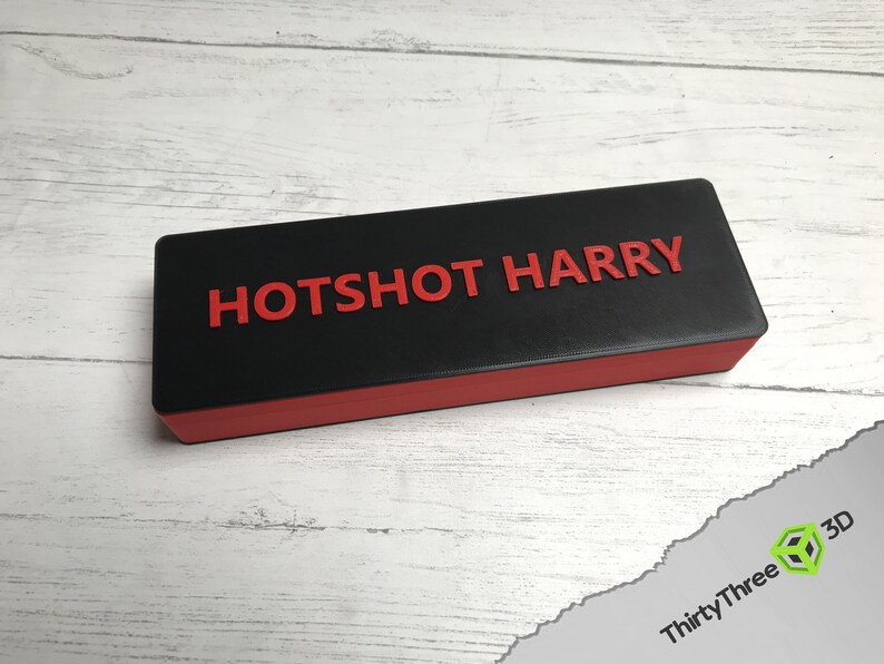 May include: A black and red rectangular box with the text "HOTSHOT HARRY" printed in red on the top.