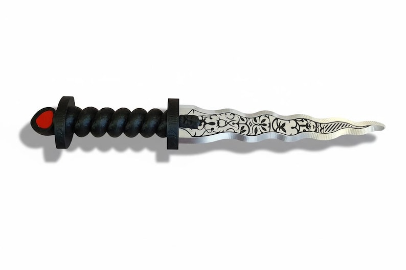 May include: A decorative dagger with a black, twisted handle and a silver blade. The blade features an ornate, etched design. The handle has a red accent on the pommel. The dagger is set against a white background.