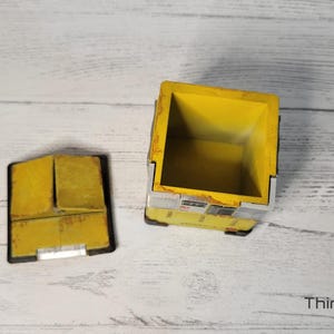 May include: A yellow and gray box with a lid. The box is open and the inside is empty. The box is made of wood and has a distressed look.