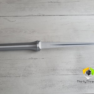 May include: A silver-colored, 3D printed dagger with a pointed tip and a textured handle.