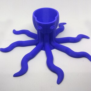 May include: A blue 3D printed octopus shaped planter with a round opening at the top. The planter has eight tentacles.