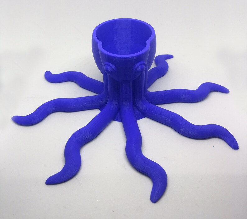 May include: A blue 3D printed octopus shaped planter with a round opening at the top. The planter has eight tentacles.