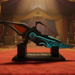 May include: An ornate black and teal dagger with a detailed design, presented on a black stand. The dagger has a teal honeycomb pattern and the text "Prince of Persia" on the stand.
