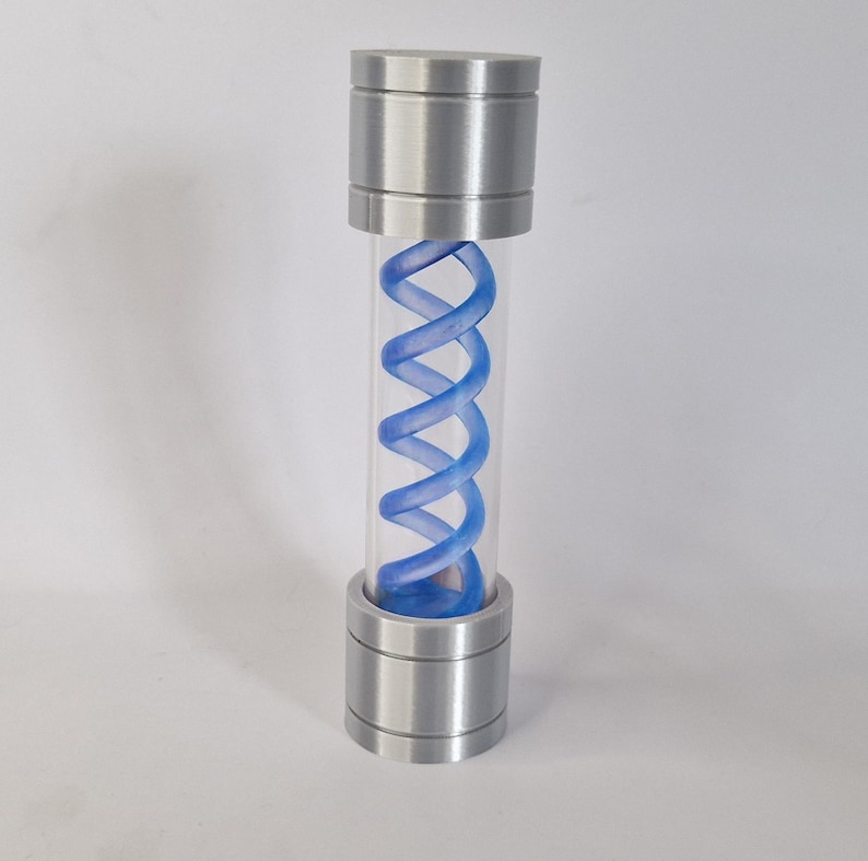 May include: A cylindrical container with a clear tube and metallic silver caps at the top and bottom. Inside the tube is a blue, double-helix shaped structure. The container is standing upright against a white background.