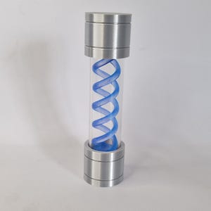 May include: A cylindrical container with a clear tube and metallic silver caps at the top and bottom. Inside the tube is a blue, double-helix shaped structure. The container is standing upright against a white background.