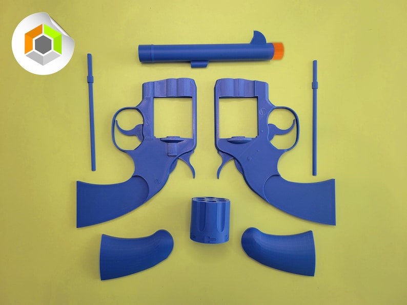 Op de afbeelding: Een gedemonteerde speelgoedpistoolset van blauw plastic, met twee pistoolframes, een loop met een oranje punt, een cilinder, twee handgrepen en twee staven. De onderdelen zijn gerangschikt op een gele achtergrond.