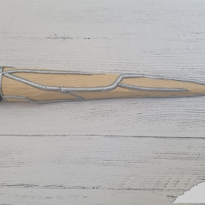 Op de afbeelding: Een beige en zilveren 3D-geprint rekwisietwapen met een puntige punt en een textuur.
