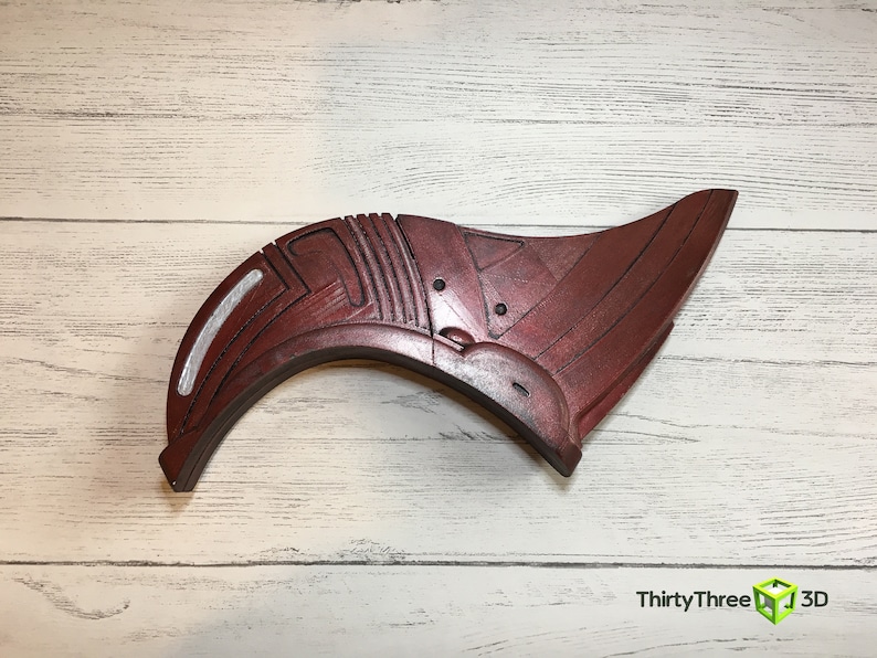 May include: A red and silver 3D printed prop shaped like a curved wing with intricate details. The prop is made of plastic and has a smooth finish.