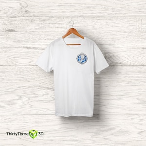 May include: White t-shirt with a blue and silver circular graphic on the front. The graphic features a stylized octopus with a globe inside the circle.