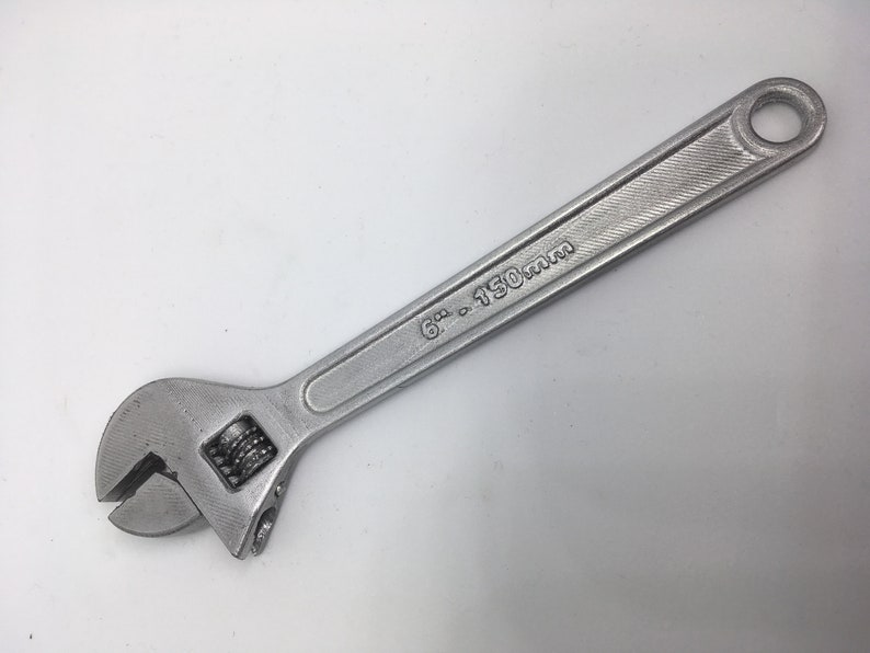 Puede incluir: Una llave inglesa de plata con una medida de 6 pulgadas a 150 mm marcada en el mango.