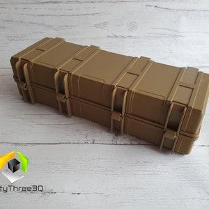 May include: A tan-colored, rectangular hard case with multiple latches and clasps. The case is made of a durable plastic material and has a textured surface.