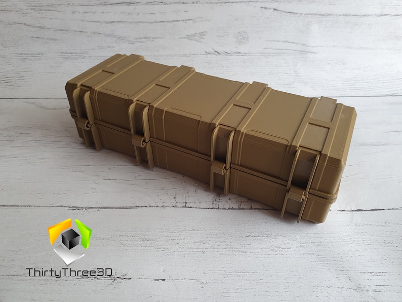 May include: A tan-colored, rectangular hard case with multiple latches and clasps. The case is made of a durable plastic material and has a textured surface.
