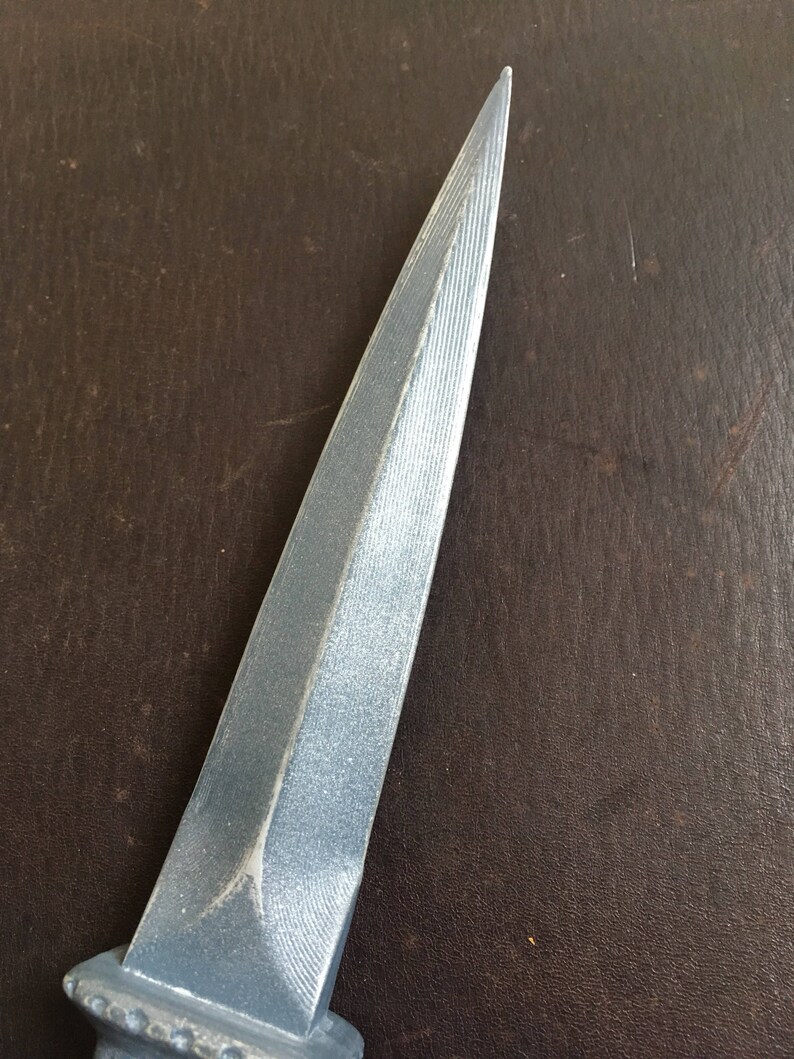 May include: A silver dagger with a pointed tip and a textured blade.