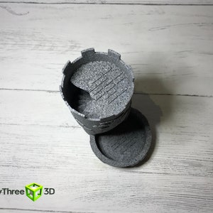 May include: A gray 3D printed tower with a crenellated top and a textured surface. The tower is in two pieces, with the top piece sitting on the bottom piece.