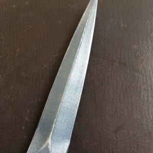 May include: A silver dagger with a pointed tip and a textured blade.