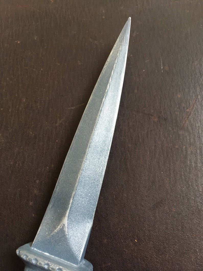 May include: A silver dagger with a pointed tip and a textured blade.