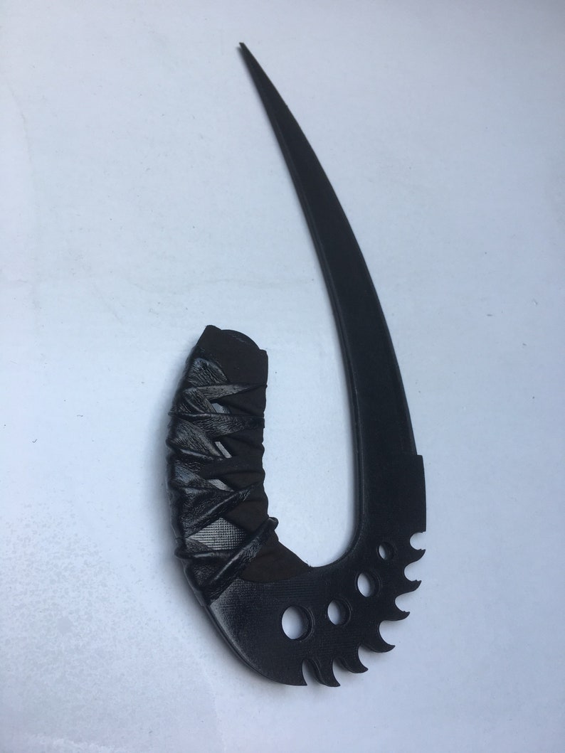 May include: A black, curved, and serrated blade with a black, wrapped handle. The blade is sharp and pointed, and the handle is textured.