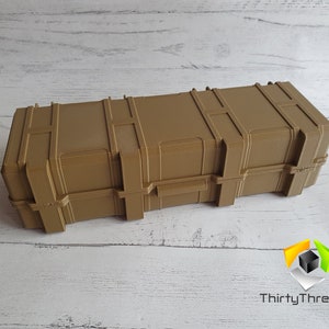 May include: A tan-colored plastic storage case with a latch and a textured surface. The case is rectangular and has a long, narrow shape.