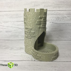 May include: A gray stone tower-shaped dice rolling tower with a rounded base. The tower has a small opening at the top and a larger opening at the base.