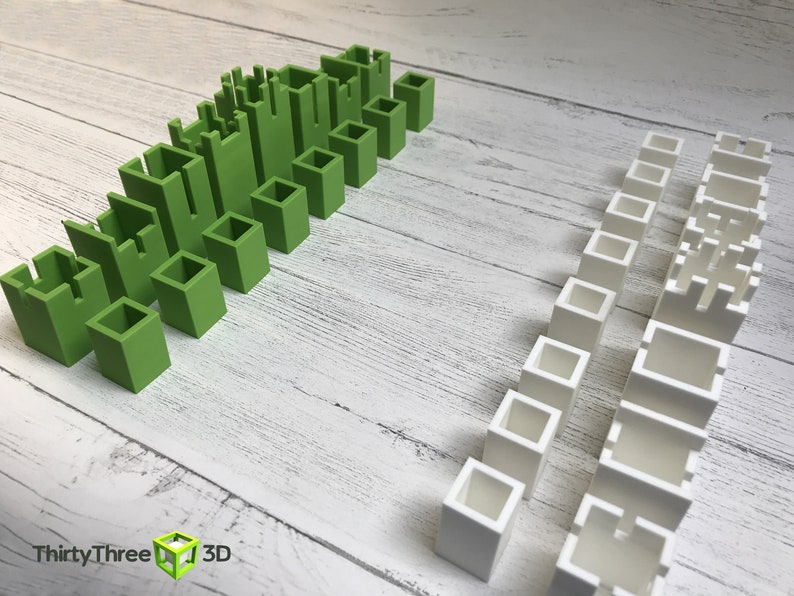 May include: Two sets of green and white plastic building blocks. The green blocks are arranged in a staggered pattern, while the white blocks are arranged in a straight line.