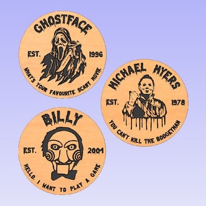 Op de afbeelding: Drie ronde houten onderzetters met zwart-wit illustraties van horrorfilmkarakters. De onderzetters tonen Ghostface uit Scream, Michael Myers uit Halloween en Billy uit Saw. Elke onderzetter bevat tekst met de naam van het personage, het jaar van uitgave van de film en een slogan.